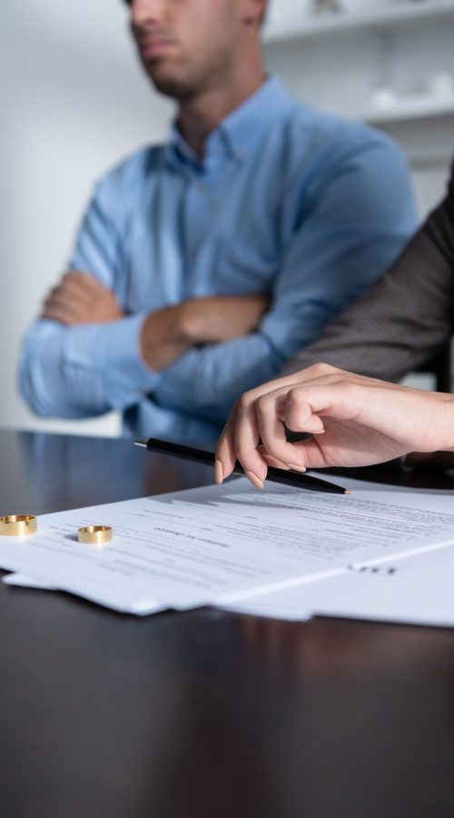 partial view of couple at table with divorce documents